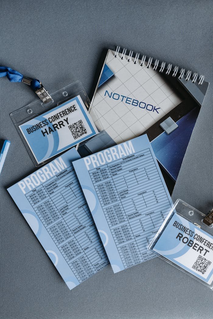 High angle shot of business conference name tags and program sheets on a gray surface.